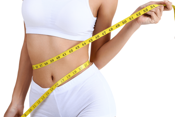 Woman in athletic wear highlighting abdominal area for weight loss wellness program